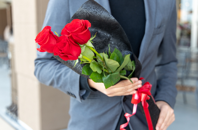 バラの花束を持つ男性