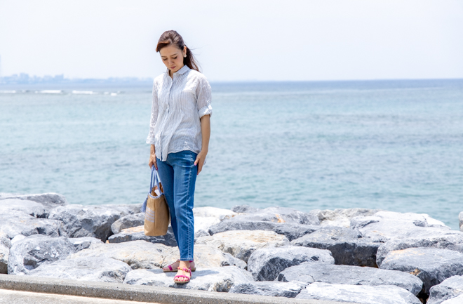 海を背景に立つ女性